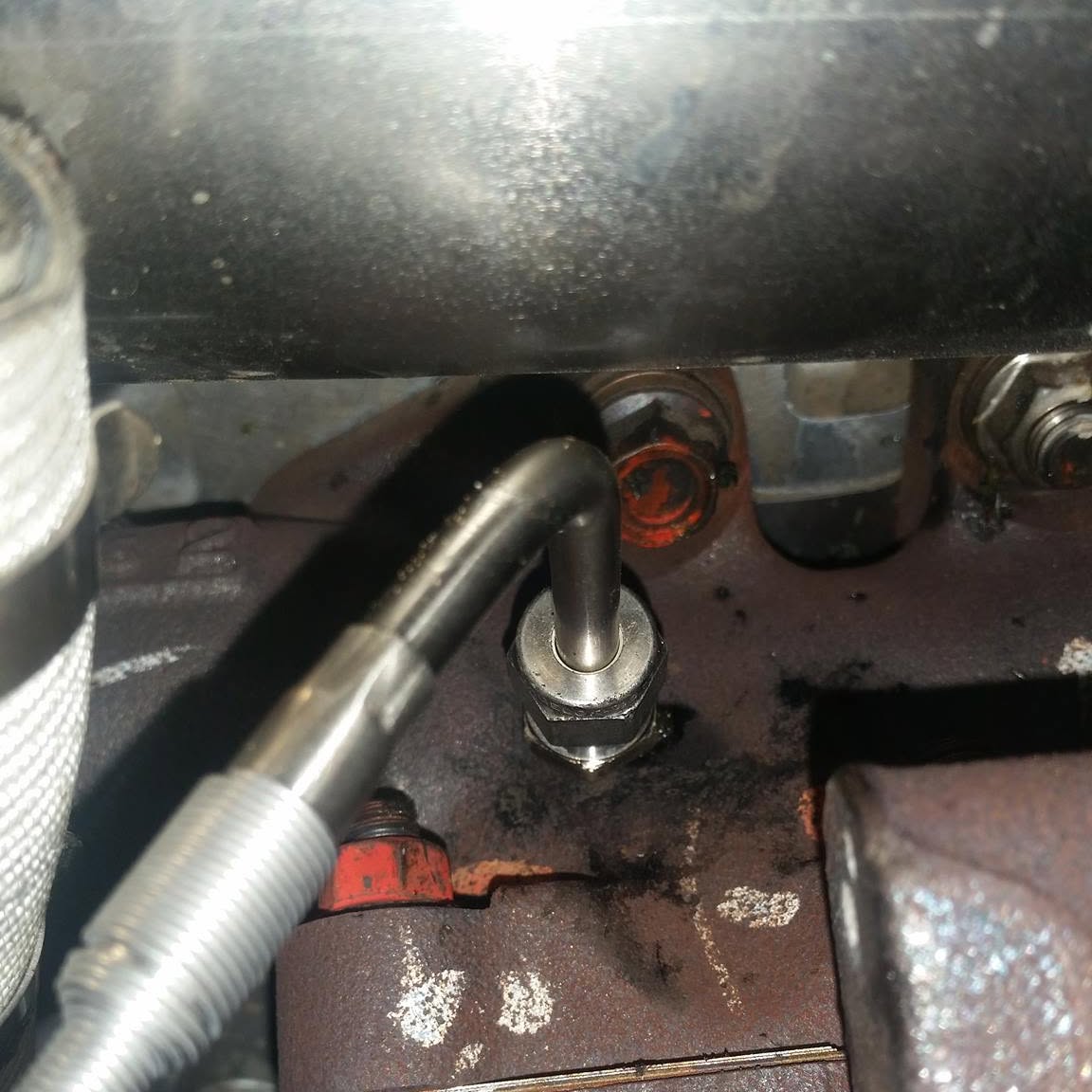 A new stainless line fitted against a corroded engine block
